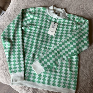 Grön och vit rutig stickad tröja från Object - Säljer en stickad tröja från Object i storlek S. Tröjan har ett grönt och vitt rutmönster, ribbade muddar och krage samt lång ärm. Aldrig använd, nypris 399. 