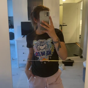Svart t-shirt med broderad tiger från Kenzo - Svart t-shirt från Kenzo med en stor, färgglad broderad tiger på bröstet och texten 'Kenzo Paris' under. T-shirten har rund hals och korta ärmar. Perfekt statement-plagg för dig som gillar att sticka ut.