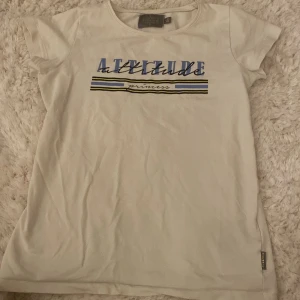 Vit t-shirt med tryck från Creamie - Vit t-shirt från Creamie med trycket 'Attitude princess' i blått, svart och gult. Skulle säga att den är vanilj vit. Den är mycket större i modellen och väldigt stretchig, skulle lika gärna kunna va xs/xxs! Kontakta innan köp🤗