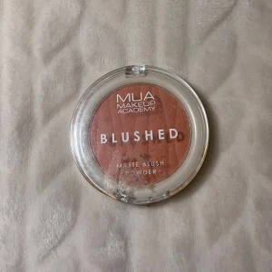 Powder blush - Matt rouge i puderform från MUA Makeup Academy i en varm, rosabrun nyans. Kommer i en rund, transparent plastförpackning med vit baksida. Perfekt för att ge kinderna en naturlig färg.