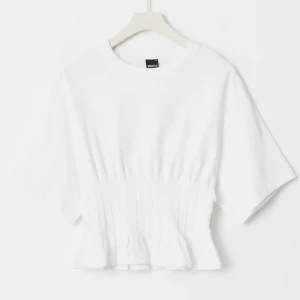 Vit ribbad topp med markerad midja - Säljer en  vit topp från ginatricot med ribbade detaljer och markerad midja. Jätte fin!💕