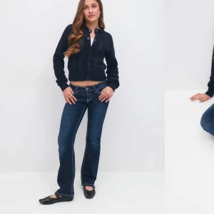 Mörkblå bootcut jeans med kontrastsömmar - Snygga mörkblå jeans med bootcut passform och tydliga vita kontrastsömmar. Byxorna har låg midja, klassiska fickor med lock och knappdetaljer samt en markerad linning. Helt nya utan prislapp 