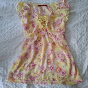 Blommig gul och rosa topp med snörning - Sötaste sommartoppen någonsi! Pastellfärgad med blommigt mönster och snörning vid bysten🌸 Köpt vintage i Saigon.