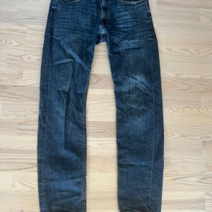 Mörkblå jeans från Dressmann - Säljer ett par mörkblå jeans från Dressmann med regular fit. Klassisk femficksmodell med knapp och dragkedja i gylfen. Jeansen har en rak passform och är tillverkade i ett slitstarkt denimtyg.