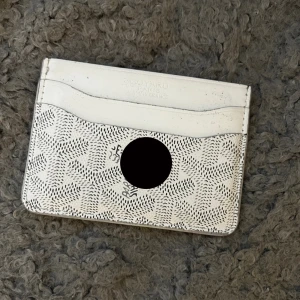 Trendig korthållare - Säljer ett stilrent vitt kortfodral med rutigt mönster. Fodralet har flera fack för kort och är perfekt för dig som vill ha något smidigt och snyggt att bära med dig. Passar perfekt i fickan eller en liten väska.