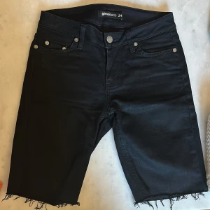 Svarta lågmidjade jeansshorts Gina Jeans - Svarta lågmidjade jeansshorts från Gina Jeans med snygga detaljer på bakfickorna. 