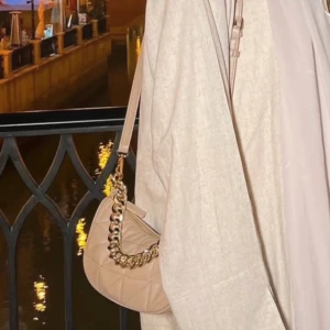 Beige väska med gulddetalj - Helt ny väska, aldrig fått användning för den✨ Priset är fast!  Hemma bilden är min (2 bild), men de andra är tagna från Maria Reina för att visa hur den ser ut☺️