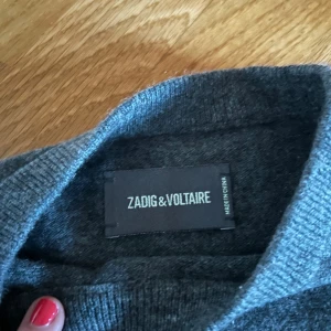Grön/grå kashmirtröja Zadig & Voltaire - Mysig kashmirtröja från Zadig & Voltaire i storlek XS. Tröjan har en glittrig stjärna på ärmen. Tillverkad i 100% kashmir. Använd endast fåtal gånger, syns inte. 