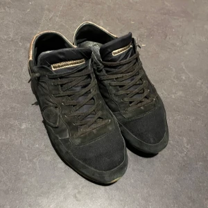 Svarta sneakers från Philippe Model - Svarta sneakers från Philippe Model med snygga detaljer i mocka och textil. Mycket slitna under skorna lite sne på vänsterfoten men annars suveräna🔥