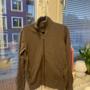 Brun full zip från Massimo Dutti i ull/kashmir (M) - Säljer en brun full zip från Massimo Dutti i en lyxig mix av ull och kashmir. Koftan har hel dragkedja framtill, hög krage och två fickor. Storlek M