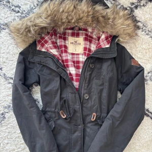 2000s jacka med päls från Hollister - Vintage jacka i storlek S från 2000-talet från Hollister med rödvitrutig insida och pälsluva. Otroligt mysig och varm - perfekt för vintern!❄️