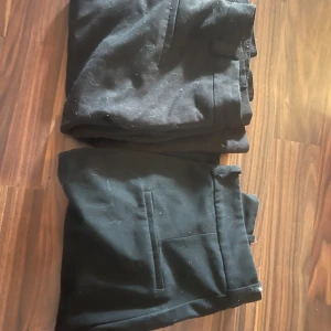 Svarta kostymbyxor H&M & Amisu - Två par svarta kostymbyxor, ett från H&M i storlek 44 och ett från Amisu i storlek 42. Klassisk rak modell med fickor fram, perfekta till en clean och stilren look. Materialet är mjukt och följsamt, passar till dig som gillar enkel och snygg stil.