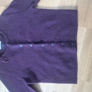 vinröd kofta  från Gina Tricot - En vinröd kofta från Gina Tricot i ullmix.enkel design utan mönster eller detaljer. Perfekt för dig som gillar en clean och stilren look.