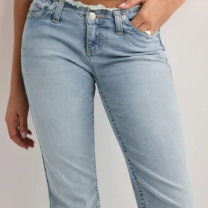 Nelly no waist bootcut jeans - Säljer ett par ljusblå bootcut jeans med fransad kant nertill och klassiska fickor bak. Jeansen har normal passform och är tillverkade i stretchigt denimtyg. De ska vara fransiga där nere och uppe och de har inga defekter förutom möjligtvis lite där nere men det syns inte 💞🙌 original pris 700kr