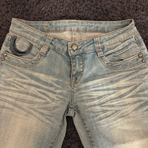 Ljusblå jeans med broderade fickor - Säljer ett par ljusblå jeans från K-Star med snyggt slitna detaljer och broderade bakfickor. Lite mer åt det raka hållet i passformen och väldigt lågmidjade. Säljer då de tyvärr var för små för mig💕midjemått: 37/38   innerben: 79