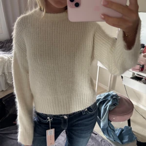 Vit stickad tröja från H&M Divided - Supermysig vit stickad tröja från H&M Divided i storlek S. Tröjan har en rak passform, ribbade muddar och är långärmad. Perfekt för lager-på-lager och passar till både jeans och kjol. Materialet är fluffigt och ger en riktigt cozy känsla.