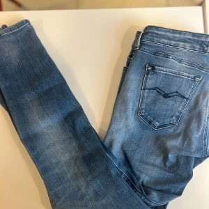 Blå Replay jeans - Snygga blå jeans från Replay med klassisk tvätt och coola broderade bakfickor. Jeansen har normal passform och raka ben, tillverkade i mjukt denimtyg som sitter skönt hela dagen. Perfekta för en avslappnad och trendig look.