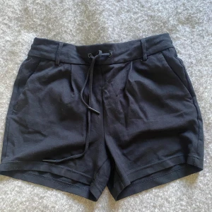 Svarta shorts från ONLY st S - Svarta shorts från ONLY med elastisk midja och snörning framtill. De har två sidofickor och två bakfickor för en chill look. Tillverkade i mjuk bomull, storlek S.