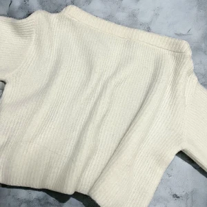 Vit ribbad stickad tröja - Mysig vit stickad tröja med ribbad struktur och lång ärm. Perfekt för kyligare dagar och enkel att matcha med olika outfits. Tröjan är off shoulder men skulle kunna användas som vanligt också. Finast som off shoulder! 