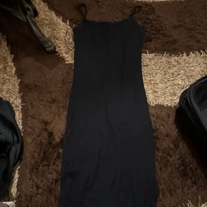 Svart långklänning med smala axelband - Säljer en stilren svart långklänning med smala axelband. Köptes i New Yorker samt använts runt 4 gånger dock är den i bra skick. Köptes för 199kr säljer den för 50kr samt är den i storlek 34 men passar också folk med 36-38.