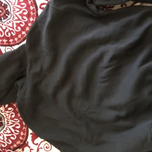 Svart hoodie - Säljer en klassisk svart hoodie med långa ärmar. Perfekt för en avslappnad stil. Passar bra till jeans eller mjukisbyxor.