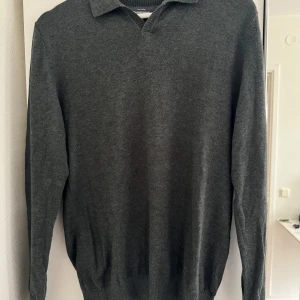 Mörkgrå stickad tröja med krage från Dressmann - Säljer en stilren mörkgrå stickad tröja från Dressmann i storlek S. Tröjan har klassisk krage, lång ärm och ribbade muddar vid ärmslut och nederkant. Perfekt för lager-på-lager och enkel att matcha med det mesta. Hör av er vid funderingar ✅