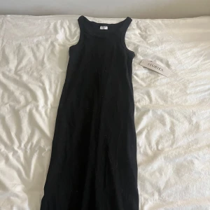 Svart ribbad långklänning från Stories - Säljer en svart supersnygg ribbad långklänning från Stories i storlek XS. Klänningen är ärmlös med rund halsringning och har en tight passform. Perfekt för en stilren och enkel look. Aldrig använd och inga fläckar eller hål❣️