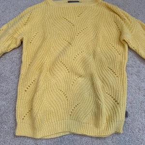 Gul stickad tröja från Creamie - Säljer en söt gul stickad tröja från Creamie med vågigt hålmönster. Tröjan har lång ärm och ribbade muddar vid ärmslut och nederkant. Perfekt för att liva upp garderoben med lite färg! Har aldrig använts och den är  oversized så den passar till storlek 152 