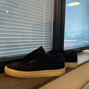 Svarta sneakers från Axel Arigato - Säljer ett par svarta sneakers från Axel Arigato. Skorna är i mocka och har en stilren design som  passar bra till de flesta outfits. Perfekta sneakers nu till vår och sommar. Skorna är väl använda och inte särskilt slitna. Nypris ligger på 2000kr. Kontakta vid frågor!!