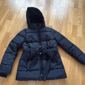 svart jacka - en väldigt fin jacka med en fin knytdetalj som ger en fin form. 