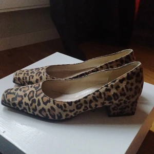 Leopardmönstrade pumps med blockklack - Säljer ett par snygga pumps från Peter Kaiser med leopardmönster och fyrkantig tå. Skorna har en stabil blockklack och är perfekta för dig som vill sticka ut lite extra. Mjukt material och klassisk form. Storleken är 4 men jag skulle säga 36,5-37