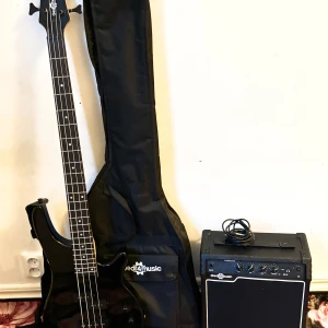 Svart elbas med förstärkare från Gear4music - Säljer en svart elbas tillsammans med en förstärkare från Gear4music. Basen har fyra strängar och levereras med en svart gigbag. Förstärkaren har flera reglage och ingång för instrumentkabel, kabel medföljer. Perfekt för dig som vill börja spela bas.