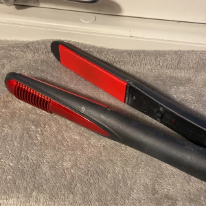 Svart och röd plattång från HAVS - Säljer en svart och röd plattång från HAVS, modell 35546. Plattången har keramiska plattor och en enkel on/off-knapp. Perfekt för att styla håret rakt eller skapa mjuka vågor. Sladd medföljer. 