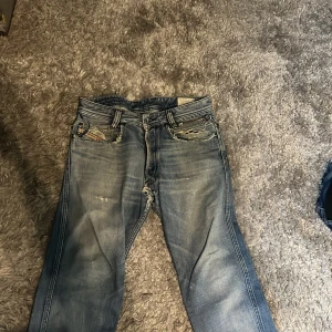 Blå slitna jeans från Diesel Paddom - Säljer ett par blå jeans från Diesel, modell Paddon, tyvärr trasiga men går att fixa om man vill sy.
