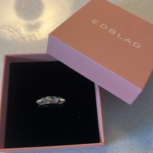 Silverfärgad ring med nitar från Edblad - Cool ring i silverfärgat metall med fem små nitar runt om. Perfekt accessoar för dig som gillar en unik stil💕Ringen är i storlek 18.50, alltså L och kommer tyyvvär inte till användning längre då  jag har bytt till guld smycken🥰Ringen är i bra skick och användes väldigt fåtal ggr❤️