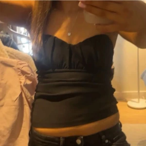 Svart tubtopp - Snygg svart oanvänd tubtopp perfekt för en fest eller en vanlig vardag. Toppen är i storleken S men skulle säga att den e mer som Xs. (Säljs för att den är för liten i storlek). 😄