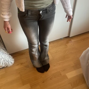 Weekday jeans - Säljer ett par grå bootcut jeansbyxor från weekday. Dom är alldeles för små på mig så det är min kompis som är på bilderna!🩷 dom är lowwaist och är i storlek 25/32 helt i nyskick, och dom är väldigt stretchiga så fom passar dom flesta även mindre och större storlekar!🩷
