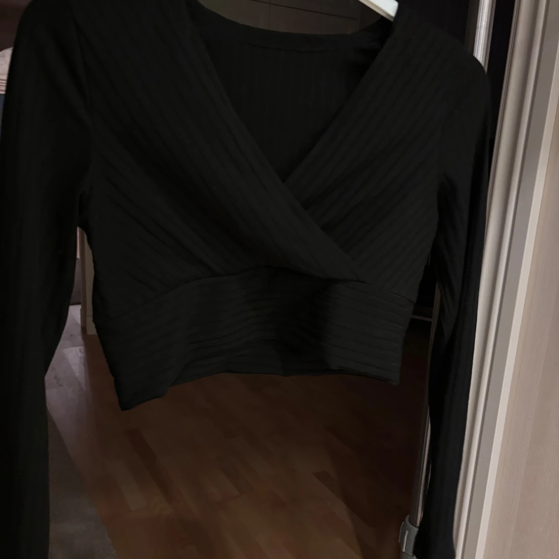 Svart omlottopp med ribbade detaljer