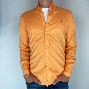 Ralph Lauren Skjorta - Nu har vi nöjet att erbjuda en klassisk  skjorta från det välkända varumärket Ralph Lauren. Plagget är i storlek Small och är i mycket gott skick, utan några synliga defekter. Modellen på bilden är 182 cm lång och väger 75 kg, vilket kan ge en god indikation på tröjans passform.