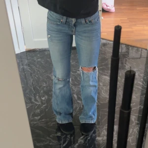 Lågmidjade bootcut jeans,Levis - Säljer mina as snygga ljusblå Levi's  jeans med snygga slitningar och hål på knäna.💕🌸dom är lågmidjade och i storlek ”24” men passar mig som vanligtvis har xs/s🥰skriv om ni vill ha fler bilder eller mått🫰🏼💕OBS Jensen är slitna längst ner då dom är lite långa på mig💕