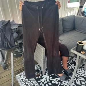 Svarta mjukisbyxor med snörning - Mysiga svarta mjukisbyxor i mjukt material med snörning i midjan och två bakfickor. Byxorna har en rak passform och är perfekta för chill dagar. Snygga att matcha med en hoodie eller t-shirt.