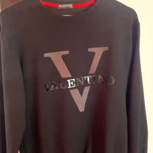 Svart Valentino sweatshirt med logga passar perfekt som L också - Säljer en svart sweatshirt från Valentino. Perfekt för dig som gillar stilrena designer och vill ha något från ett lyxigt märke. Passar perfekt för storlek L också