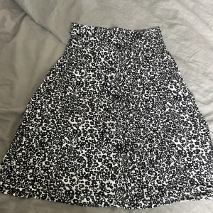 Blommig svartvit kjol från Even&Odd - Supersöt svartvit kjol från Even&Odd med blommigt mönster. Kjolen är kort och har en lätt utställd form som ger en skön vibe. Perfekt för dig som gillar att sticka ut med ett coolt print.