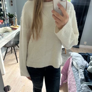 Stickad tröja Gina Tricot - Mysig lätt beige stickad tröja från Gina Tricot med rund halsringning och breda ribbade muddar. Tröjan har en loose passform och är perfekt för lager-på-lager. Enkel och stilren design som funkar till allt.