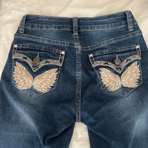 Madlady bootcut jeans med design på fickorna - Jeansen har blivit omsydda!! Egentligen är dom i storleken 34/short men nu skulle jag säga att dom är extra short (de passar mig som är 160cm), orginalpris 800kr, använda 2 gånger!!