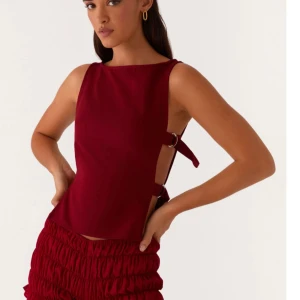 I’m looking for this top if anyone selling  - Säljer en stilren vinröd linnetopp med snygg knytning i sidan. Toppen har ärmlös design och rak halsringning, perfekt för att skapa en trendig look.