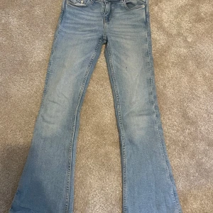 Ljusblå bootcut jeans från Gina Tricot - Säljer ett par ljusblå high wast jeans från Gina Tricot i barnstorlek 134. Byxorna har bootcut passform med utsvängda ben. Perfekta för dig som gillar en retroinspirerad stil.