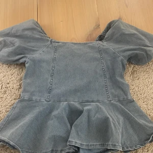 Ljusblå jeanstopp med puffärmar - !!Trendig ljusblå jeanstopp i jeansmaterial med puffiga korta ärmar och markerad midja 💕 toppen är perfekt för en snygg och välfixad outfit 💕storlek xs/s💕tyvärr vet jag ej märket 💕
