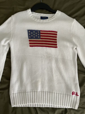 Polo Ralph lauren stickad tröja - ”The iconic flag Sweater” Storlek XL i barn storlek sitter som en S, den hänger bara i min garderob. 