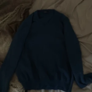 Blå stickad tröja från Oscar Jacobson - Säljer en klassisk blå stickad tröja från Oscar Jacobson. Krympt i tvätten passar s/m. 100% Merino ull från Italien!